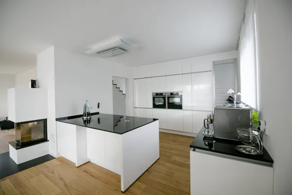 Weiße Küche mit Kochinsel und Kamin